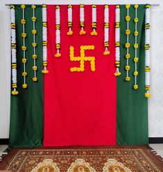 a red, green and yellow wall hanging next to a rug with flowers on it