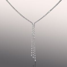 This sleek diamond drop necklace exudes a luxuriant aura while embracing minimalism and modernity. It boasts a streamlined eternity necklace design that extends to a stunning diamond waterfall pendant. The pendant is composed of strands of diamonds, set at different heights, falling softly along the neck and into the décolletage. Gemstone Pendants, Luxury Long Drop Diamond Backdrop Necklace, Luxury White Gold Long Drop Necklace, Luxury Diamond Long Drop Lariat Necklace, Luxury Diamond-accented Drop Necklace For Wedding, Luxury White Diamond-shaped Necklace, Diamond Drop Necklace, Modern Necklaces, Diamond Drops