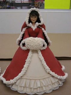 a doll is dressed in a red and white dress