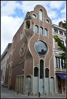 an unusual building in the middle of a street with lots of windows on it's side