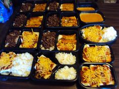 a table topped with lots of trays filled with different types of food and condiments