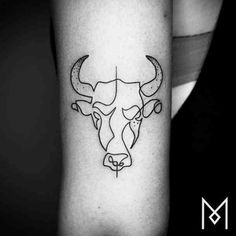 a black and white photo of a bull's head on the arm with an arrow