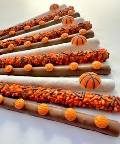 an assortment of candy sticks decorated with basketballs and orange candies on white background