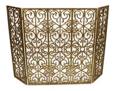 an ornate gold metal screen with scrolls and flowers on the sides, set against a white background