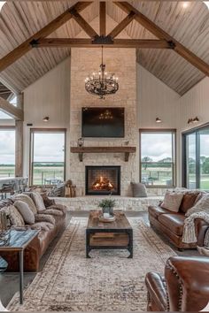 a living room filled with furniture and a fire place in the middle of an open floor plan