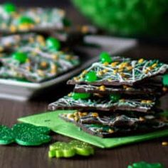 several pieces of green and white chocolate on a table with shamrocks around them,