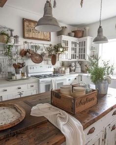 a kitchen filled with lots of white appliances and wooden counter top covered in pots and pans