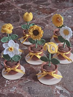 small crocheted flower pots with flowers in them sitting on top of each other