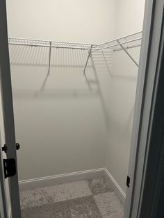 an empty walk - in closet with white walls