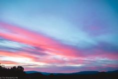 the sky is pink and blue at sunset