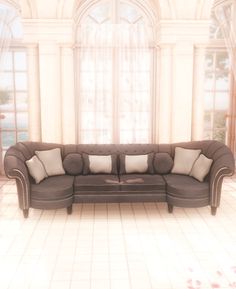 a large couch sitting in the middle of a living room next to a tall window