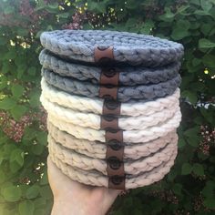 a hand holding a stack of knitted rope with black circles on the top and bottom