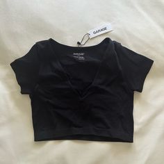 Never Worn Tag Still On Cropped V Neck Tee From Garage! 94% Nylon, 6% Spandex Size Medium Black Stretch V-neck Crop Top, Black High Stretch V-neck Top, Black V-neck Workout Top, Casual Black Crop Top With Medium Support, Black Seamless V-neck Top, Seamless V-neck Tops With Medium Support, Seamless Medium Support V-neck Tops, Black Sports Crop Top For Spring, Black Fitted Top