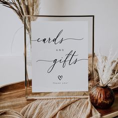 a sign that says cards and gifts on it next to some dried plants in a vase