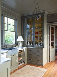 a kitchen with gray cabinets and wood floors