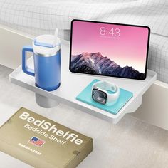 the bed side shelf is holding an ipad, camera and coffee mug