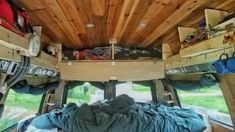 the inside of a camper with wood paneling and sleeping bags on it's bed