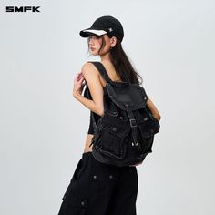 SMFK Compass Tarpan Denim Backpack Black (Large) - Design: A fresh design for 2024 by SMFK, this denim backpack is a new addition to their collection. The design takes inspiration from common detailing found in denim jackets and shorts, allowing for adjustable capacity. Features a three-dimensional external pocket, echoing the workwear pocket style from SMFK's workwear collection. Size F - Length: 35cm, Width: 17.5cm, Height: 41cm Composition: 72.8% Cotton, 23.6% Polyester, 3.6% Viscose Trendy Canvas Backpack With Pockets, Trendy Cotton Backpack With Pockets, Casual Backpack With Multiple Pockets, Streetwear Backpack With Pockets, Black Cotton Backpack With Pockets, Trendy Backpack With Multiple Pockets, Casual Streetwear Backpack With Adjustable Strap, Denim Backpack, Shop Bags