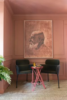 two chairs and a table in front of a painting