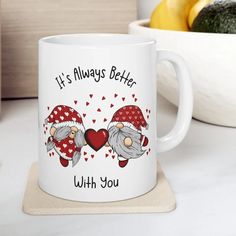 a white coffee mug with two gnomes on it and the words, it's always better with you