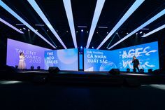 two people are standing on stage at an event with large screens behind them that read talent awards 2020