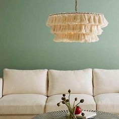 a living room filled with furniture and a chandelier hanging over the top of it