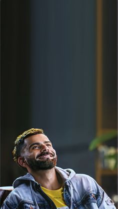 a man sitting in a chair with his eyes closed and looking up at something he is smiling for the camera