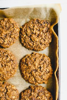 six cookies in a baking pan on top of parchment paper