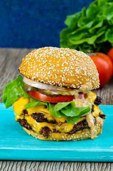 a cheeseburger with lettuce and tomato on a blue plate