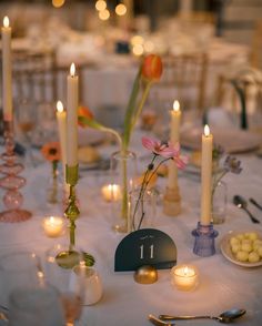 a table topped with lots of candles and plates