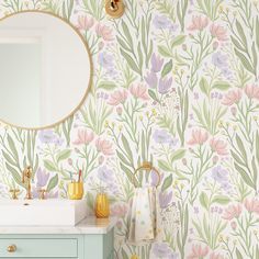 a bathroom with floral wallpaper and a mirror on the wall next to a sink