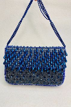 Blue front flap clutch with pure rhinestones, pearls embellishments and attached sling.
Type:Embellishment
Compositon:Raw Silk
Color:Blue
Other Details:
Bead drops
Size (inch): 8   9
Weight (gms): 500
Closure: Metal clasp - Aza Fashions Blue Rhinestone Clutch Bag, Elegant Hand Embellished Shoulder Bag For Evening, Blue Evening Bag With Rhinestones, Blue Rhinestone Clutch Evening Bag, Blue Rhinestone Clutch For Party, Blue Rhinestone Clutch For Events, Blue Handheld Evening Bag For Formal Occasions, Formal Blue Handheld Evening Bag, Hand Embellished Evening Clutch Bag