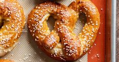 two pretzels on a tray with sesame seeds