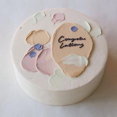 a white cake with pink and blue frosting on it that says corporate bakings