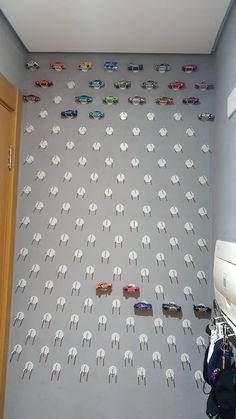 there are many toy cars on the wall in this room and it is very cool