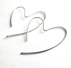 Heart Hoop Earrings in Sterling Silver Made from a single piece of Sterling Silver wire, these hoops are hammered for texture and shine. Measure about 1 1/4 inches long. Your earrings will come with rubber ear backs to help keep them in place in your ears. Join my mailing list to find out about sales and new collections: http://eepurl.com/gLcTn ◊◊ Please review my policies: http://etsy.com/shop/azizajewelry/policy ◊◊ Follow Aziza Jewelry on Instagram: http://instagram.com/azizajewelry Discounts? Open Heart Earrings, Hammered Hoop Earrings, Light Weight Jewelry, Heart Hoop Earrings, Heart Dangle Earrings, Asheville Nc, Open Heart, Hammered Silver, Sterling Silver Hoops