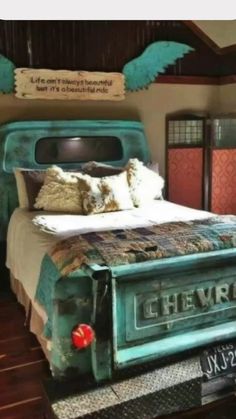 a bedroom with a bed made out of an old truck and wings on the headboard