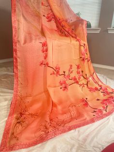 Vibrant and pretty blended satin silk saree in shades of orange. Floral vines is printed on the top portion of the pallu with pebble like prints on the lower part.Pleats will be a bright orange with floral sequins in the bottom part and continues as bright orange towards the end of the saree. Sequin lace borders runs along the saree. Comes with fall, pico and completely stitched blouse. Saree width: 43 inch Blouse details: Back hook with mild puff along the sleeves. chest size: 36 with 3 inch margin waist size: 32 with 3 inch margin Arm hole: 18 inch sleeve length: 11 inch Length: 14 inch Maintenance: Dry wash advisable Returns and refund only accepted on defective products. Product should be shipped back in 3 days after delivery . Please go through our return policies below. Our Policy on Red Silk Dupatta With Digital Print, Bollywood Style Orange Saree With Printed Border, Red Silk Saree With Floral Print, Orange Dupatta With Printed Border For Diwali, Elegant Orange Saree Blouse Piece, Festive Orange Silk Dupatta, Traditional Orange Saree With Printed Border, Orange Saree With Printed Border, Orange Saree With Printed Border In Traditional Drape