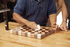 two men are playing checkers on a wooden table