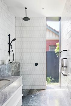 a bathroom with white tiles and black fixtures