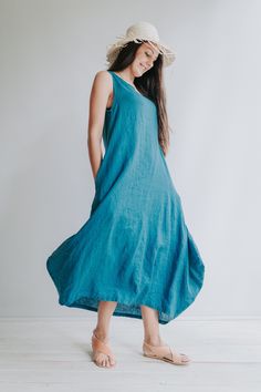 "A fantastic loose and comfortable trapeze linen dress with pockets and a great scoop neckline. Made from 100% pure European linen with its characteristic wonderful texture. Each piece is individually cut, sawn and pre-washed. In the images you see the dress made from light weight teal linen. Perfect for beach and any other setting where you want to be comfortable. A beautiful drape that will make you feel like a queen. Widens up towards the bottom with exaggerated corners just above the hem. Fu Flowy Linen Dresses, Unlined, Flowy Linen Dresses Unlined, Flowy Sleeveless Linen Casual Dress, Flowy Sleeveless Linen Dress Casual, Flowy Linen Sleeveless Sundress, Relaxed Fit Sleeveless Unlined Maxi Dress, Flowy Sleeveless Dresses With Pockets, Sleeveless Relaxed Fit Maxi Dress With Pockets, Sleeveless Dresses With Side Pockets And Relaxed Fit