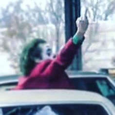 the joker is waving from his car window