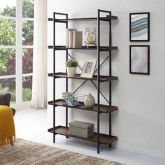 a living room with a book shelf in the middle and pictures on the wall behind it