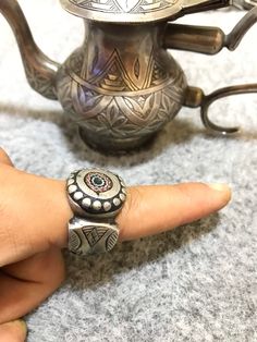 Very beautiful Tuareg/Sahrawi ring from South Morocco made out of high grade silver and ornated with a chevron bead which is said it protects from evil eye. Size : US : 10 FR : 63 Diameter of the stone : 1cm Weight : 25,3g Ceremonial Artisan Sterling Silver Rings, Artisan Sterling Silver Rings For Ceremonial Occasions, Bohemian Handmade Sterling Silver Engraved Ring, Handmade Bohemian Sterling Silver Engraved Ring, Bohemian Engraved Toe Ring, Bohemian Engraved Open Ring, Traditional Antique Silver Ring Jewelry, Traditional Antique Silver Ring, Traditional Handmade Antique Silver Rings