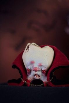 a creepy doll with blood on its face and eyes is sitting in front of a dark background