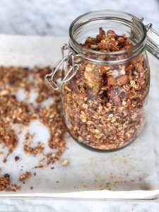 a glass jar filled with granola sitting on top of a white tray