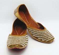 Ethnic Indian/Pakistani style shoes durable and hand stitched with genuine leather sole and leather padded cushion inside. A beautiful color of gold with white stones that are lined around the shoe to give a more unique design! Our shoes are perfect gift for a friend, gift for a bride, or gift for yourself. These shoes are absolutely beautiful. Sizes available US 6,7,8,9,10. Shipped from USA Traditional Gold Closed Toe Flats, Gold Closed Toe Flats With Dori Work, Gold Traditional Slip-on Flats, Gold Flats With Zari Work And Round Toe, Traditional Gold Flats For Festivals, Gold Slip-on Flats With Dori Work, Gold Flats With Handwork For Transitional Season, Gold Round Toe Flats For Diwali, Gold Slip-on Traditional Flats