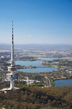 an aerial view of a tower with a lake in the foreground and trees surrounding it