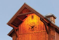 a tall wooden building with a clock on it's side