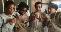 four women in aprons are holding drinks